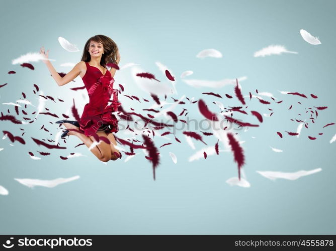 Jumping woman. Young attractive woman in red dress jumping high