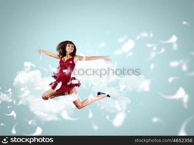 Jumping woman. Young attractive woman in red dress jumping high