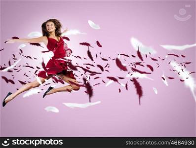 Jumping woman. Young attractive woman in red dress jumping high