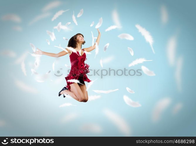 Jumping woman. Young attractive woman in red dress jumping high