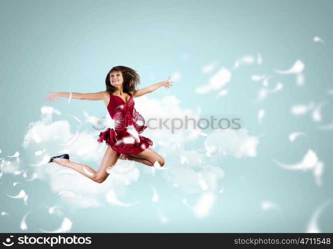 Jumping woman. Young attractive woman in red dress jumping high