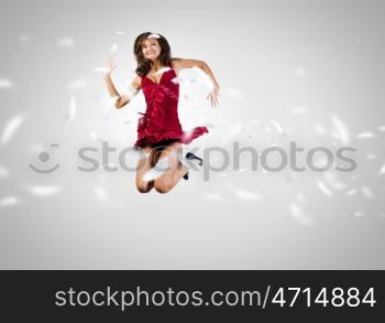 Jumping woman. Young attractive woman in red dress jumping high