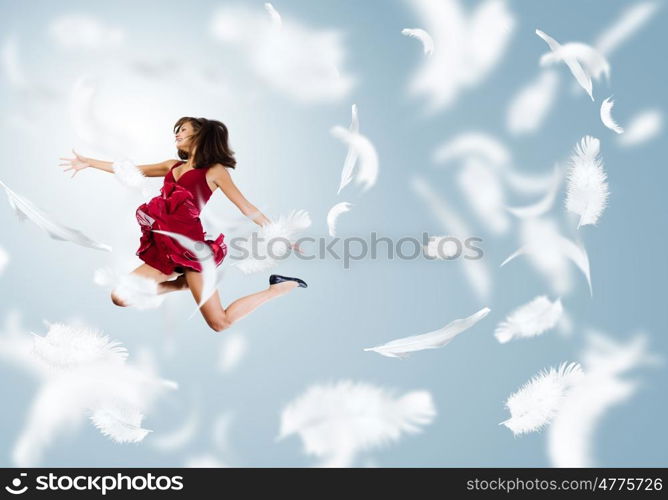 Jumping woman. Young attractive woman in red dress jumping high