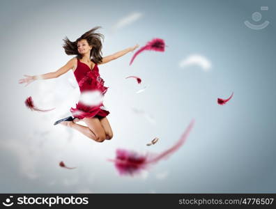 Jumping woman. Young attractive woman in red dress jumping high