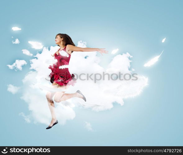 Jumping woman. Young attractive woman in red dress jumping high