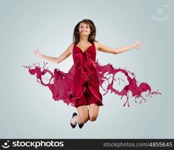 Jumping woman. Young attractive woman in red dress jumping high