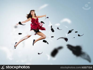 Jumping woman. Young attractive woman in red dress jumping high