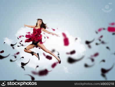 Jumping woman. Young attractive woman in red dress jumping high