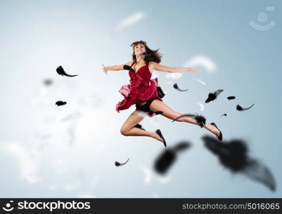 Jumping woman. Young attractive woman in red dress jumping high