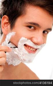 Junger Mann rasiert sich mit Rasierklinge Und Rasierschaum im Badezimmer
