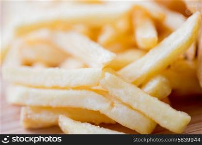 junk-food, fast food and eating concept - close up of french fries on table