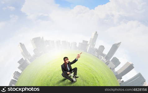 Just like a child. Young funny businessman riding three wheeled bicycle