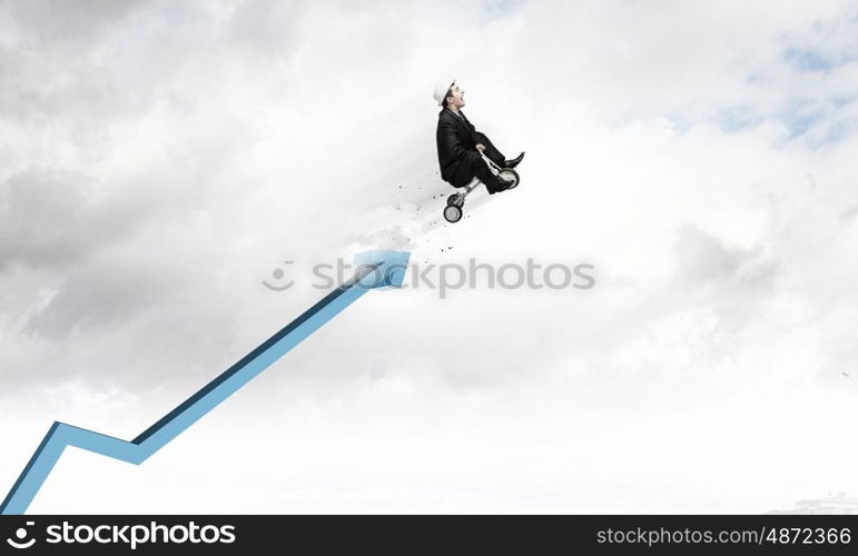 Just like a child. Young funny businessman riding three wheeled bicycle