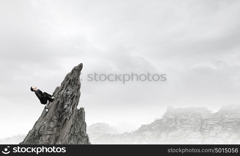 Just like a child. Young funny businessman riding three wheeled bicycle