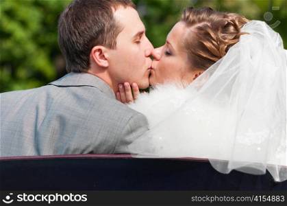 just married couple is kissing in park