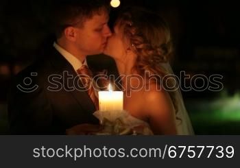 just married couple kissing by candlelight at night