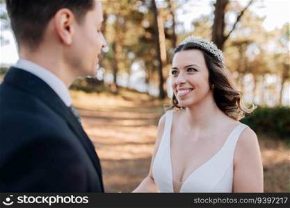 Just married couple looking at each other on a forest