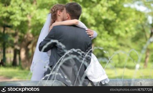 just married couple sitting near the fountain