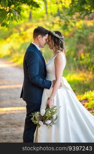 Just married couple touching their foreheads on a green forest