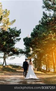 Just married couple walking on a forest at sunset