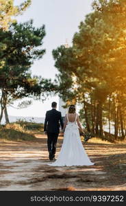 Just married couple walking on a forest at sunset