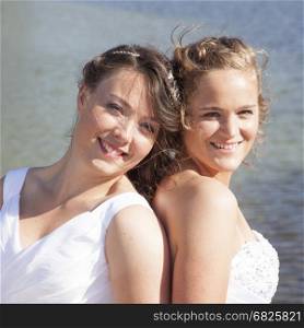 just married happy lesbian couple together near water of small lake sunny day