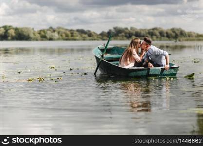 Just relaxing. Beautiful young couple enjoying romantic date while rowing a boat. Just relaxing. Beautiful young couple enjoying romantic date while rowing a boat. Loving couple resting on a lake while riding a green boat. romance.