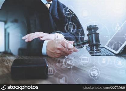 justice and law concept.Male judge in a courtroom with the gavel,working with digital tablet computer docking keyboard on wood table,virtual interface graphic icons diagram