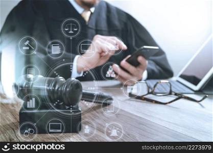 justice and law concept.Male judge in a courtroom with the gavel,working with smart phone,digital tablet computer docking keyboard on wood table,virtual interface graphic icons diagram