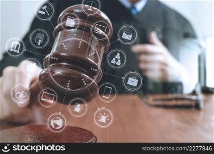 justice and law concept.Male judge in a courtroom with the gavel,working with smart phone,digital tablet computer docking keyboard,eyeglasses,on wood table,virtual interface graphic icons diagram