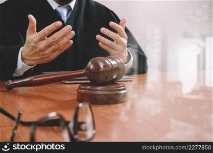 justice and law concept.Male judge in a courtroom with the gavel,working with smart phone,digital tablet computer docking keyboard,eyeglasses,on wood table,filter effect