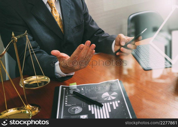 justice and law concept.Male lawyer in office with the gavel,working with smart phone,digital tablet computer docking keyboard,brass scale,on wood table,filter effect