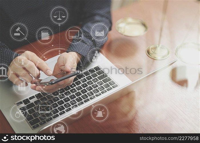 justice and law concept.Male lawyer in office with the gavel,working with smart phone,digital tablet computer docking keyboard,brass scale,on wood table,virtual interface graphic icons diagram