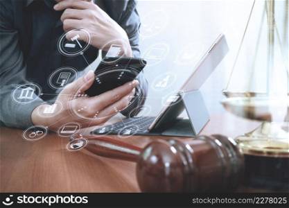 justice and law concept.Male lawyer in office with the gavel,working with smart phone and digital tablet computer and brass scale on wood table,virtual graphic icons screen diagram
