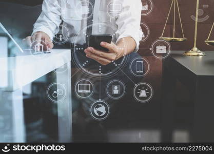 Justice and Law context.Male lawyer hand sitting on sofa and working with smart phone,digital tablet computer docking keyboard with gavel and document on living table at home,virtual interface graphic icons diagram