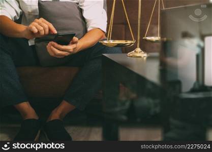 Justice and Law context.Male lawyer hand sitting on sofa and working with smart phone,digital tablet computer docking keyboard with gavel and document on living table at home,filter effect