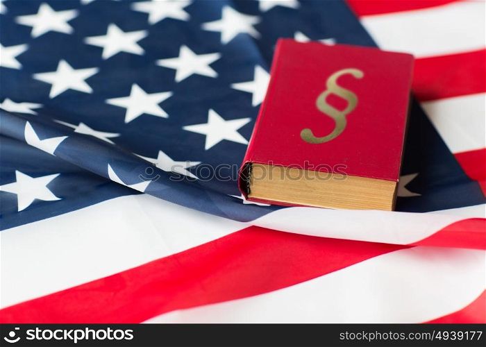 justice, law, civil rights and nationalism concept - close up of american flag and lawbook. close up of american flag and lawbook