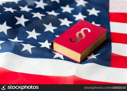 justice, law, civil rights and nationalism concept - close up of american flag and lawbook. close up of american flag and lawbook