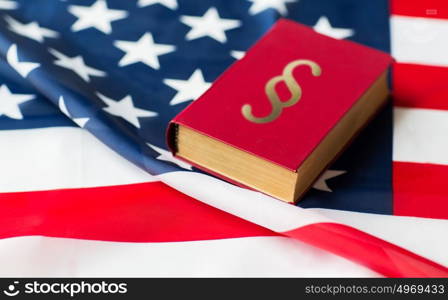 justice, law, civil rights and nationalism concept - close up of american flag and lawbook. close up of american flag and lawbook