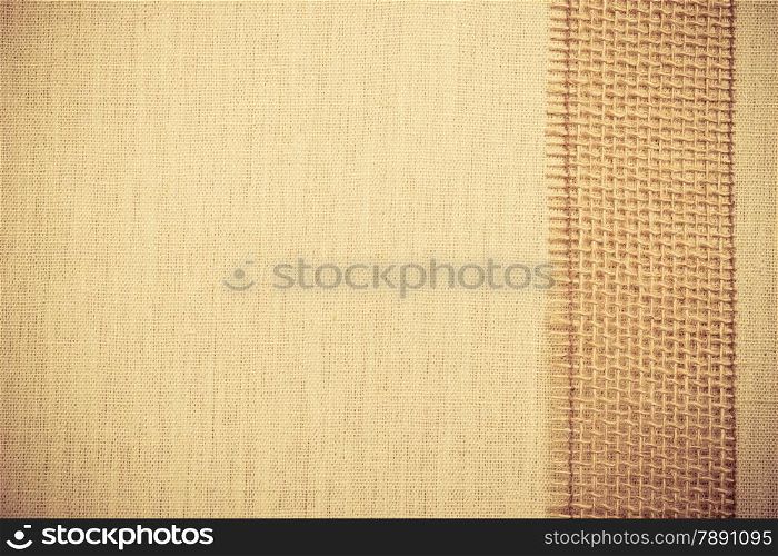 Jute bagging ribbon on bright fabric textile material, natural linen background