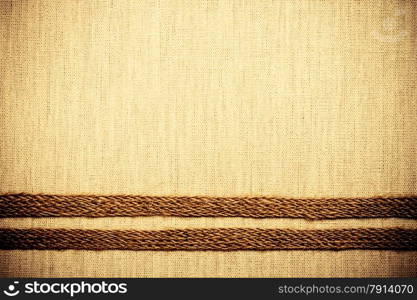 Jute bagging ribbon on bright fabric textile material, natural linen background