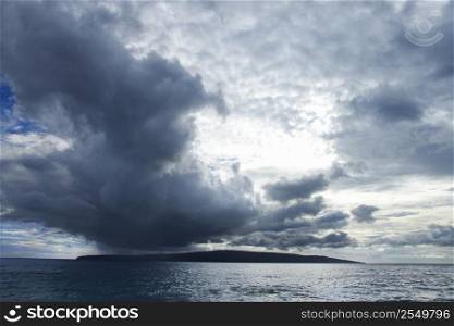Kahoolawe, Hawaii island with ocean and cloudy sky.