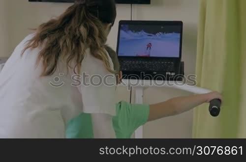 KALIKRATIA, GREECE - JANUARY 12, 2016: At the medical clinic Evexia on a robotic system analysis and training balance doctor analyzed walk of a little boy. Each year in Greece come nearly 19 million tourists and more than 15% of tourists arrive within the medical tours