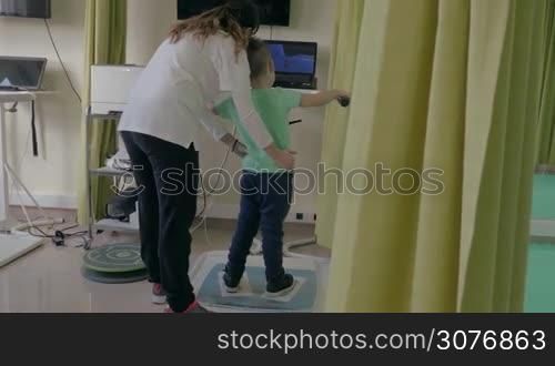KALIKRATIA, GREECE - JANUARY 12, 2016: At the medical clinic Evexia on a robotic system analysis and training balance analyzed walk of a little boy. Each year in Greece come nearly 19 million tourists and more than 15% of tourists arrive within the medical tours