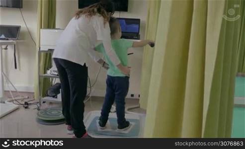 KALIKRATIA, GREECE - JANUARY 12, 2016: At the medical clinic Evexia on a robotic system analysis and training balance analyzed walk of a little boy. Each year in Greece come nearly 19 million tourists and more than 15% of tourists arrive within the medical tours