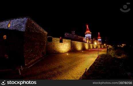 Kamianets-Podilskyi castle illuminated in different colors at night