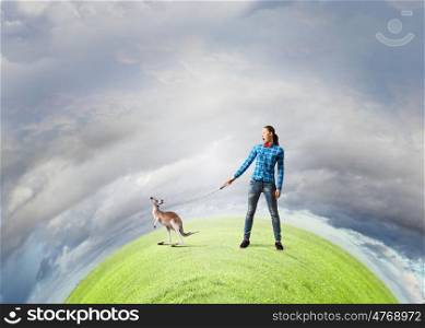 Kangaroo on lead. Young woman in casual holding kangaroo on lead