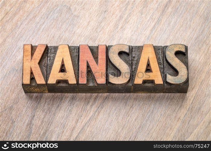 Kansas word abstract in vintage letterpress wood type against grained wooden background
