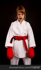 karate girl in a white kimono and red outfit prepares for a duel on a dark background. mouth guard girl