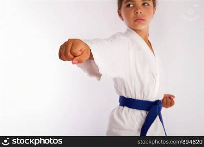 karate girl in white kimono and blue belt punch forward. little girl punch